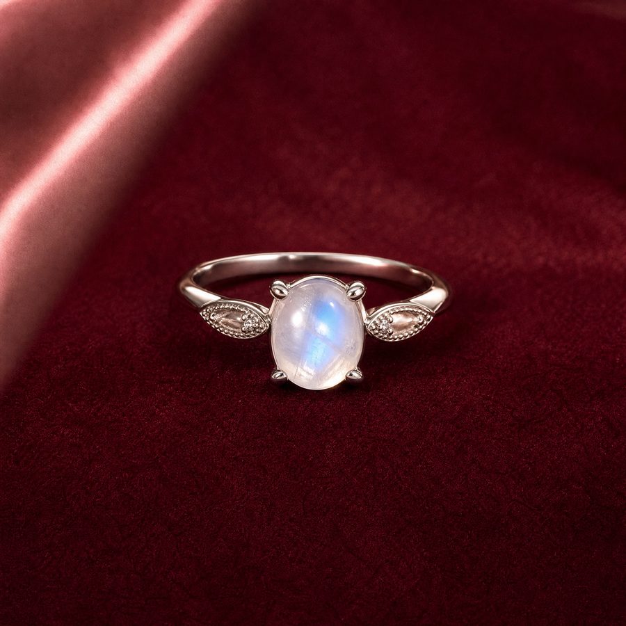 Серебряное кольцо с сияющим лунным камнем на бархатной ткани